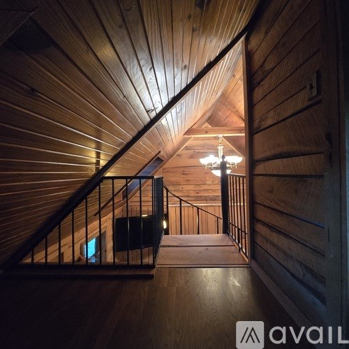 A wooden staircase with a metal railing and a light at the top.