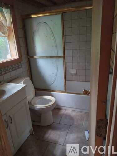 A bathroom with a toilet, sink, and tiled walls.