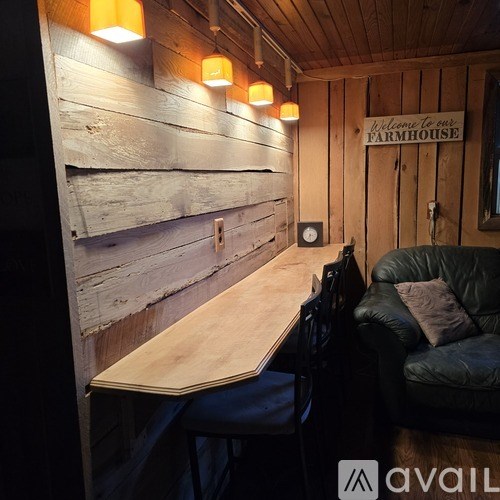 A wooden table and bench in a room with a sign that says "Welcome to our FARMHOUSE".