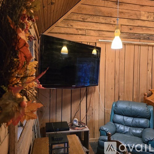 A cozy room with a TV, a chair, and a table.