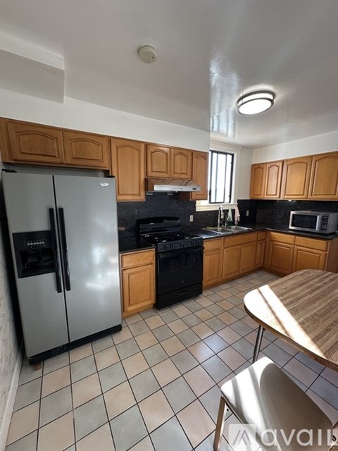 A kitchen with a refrigerator, oven, and microwave.