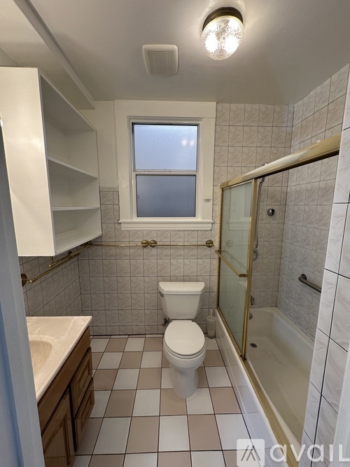 A small bathroom with a toilet, sink, and shower.