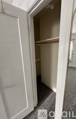 A long hallway with a carpeted floor and white walls.