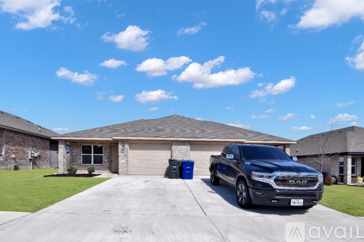 A black RAS truck is parked in front of a house.