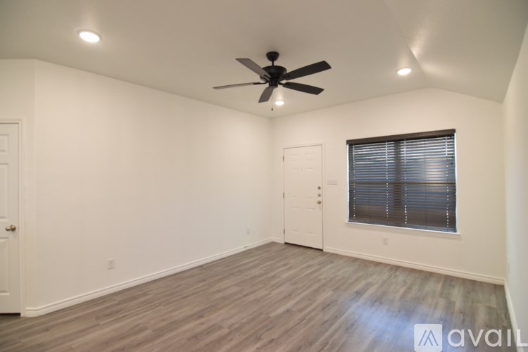 A room with a ceiling fan and a window with blinds.