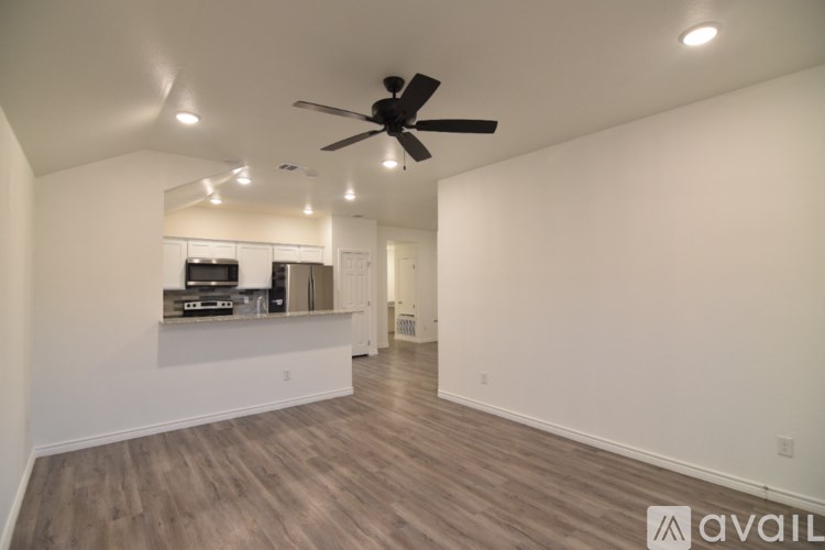 A bathroom with a granite countertop and a toilet in the corner.