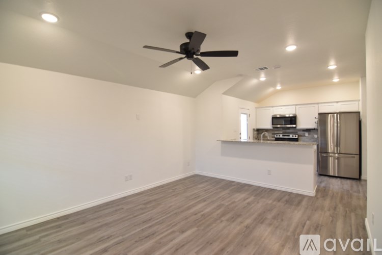 A room with a ceiling fan and a window with blinds.
