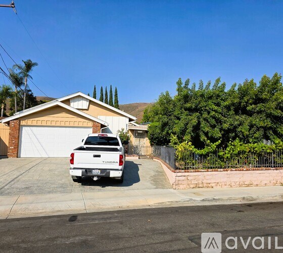 A white Tundra truck is parked in front of a house.