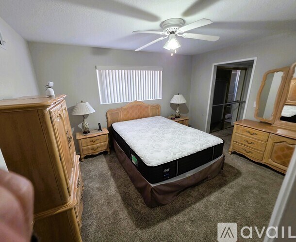 A bedroom with a bed, dresser, and nightstand.