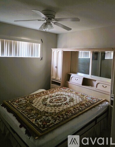 A bedroom with a bed, dresser, and mirror.