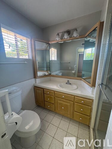 A bathroom with a toilet, sink, and mirror.
