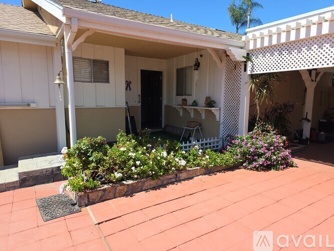 A patio area with a table and chairs under a pergola.