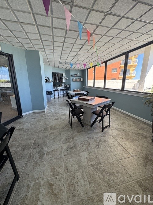 A room with a table and chairs and a window with a view of a building.