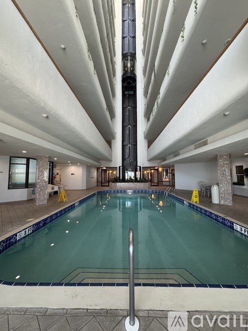 A large indoor swimming pool with a diving board.