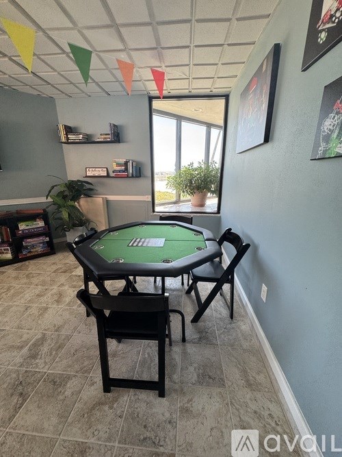 A poker table with chairs in a room with a window.