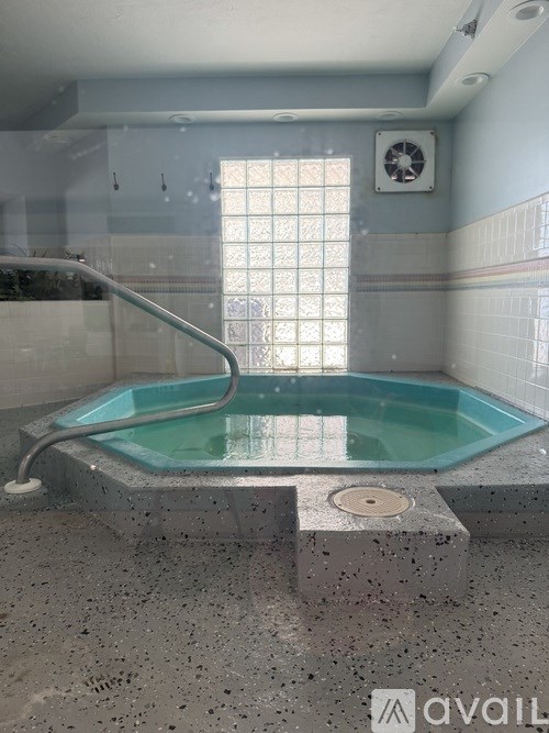A tiled bathroom with a glass shower door and a glass tub.
