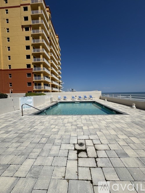 A large pool on a patio with a building in the background.