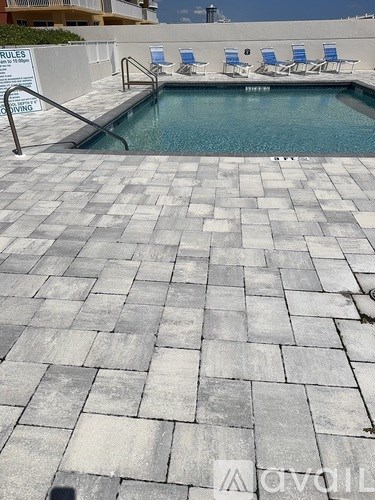 A pool with a sign that says "rules" in the background.