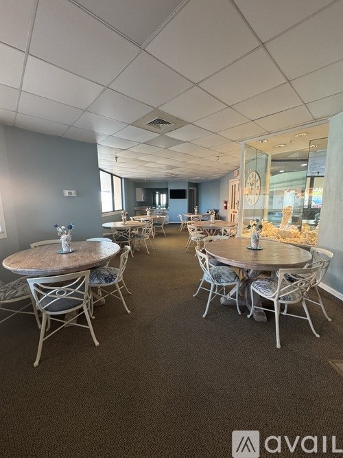 A room with tables and chairs and a logo that says "avail".