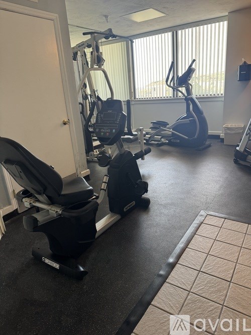 A gym with a treadmill, elliptical trainer and a stationary bike.