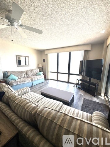 A living room with a striped couch and a television.