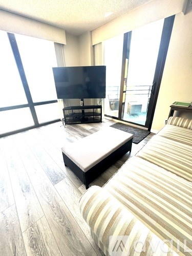 A modern living room with a flat screen TV and a striped sofa.
