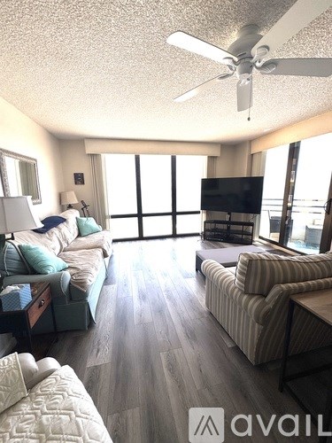 A living room with a striped couch and a flat screen TV.