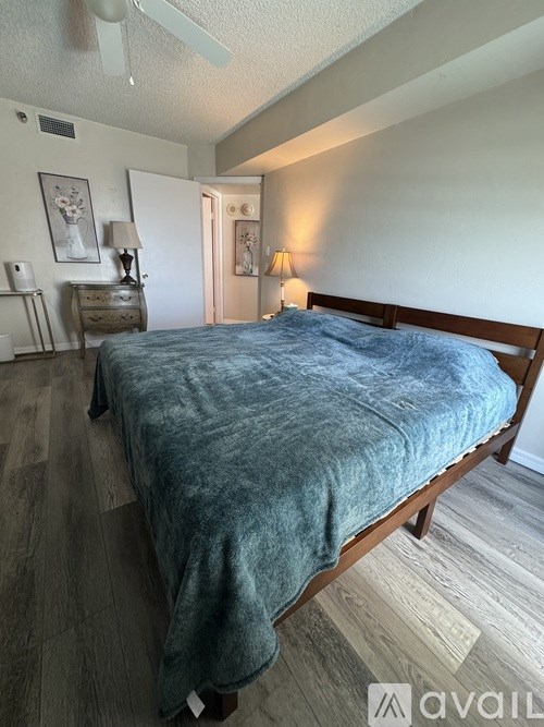 A bedroom with a bed, nightstand, and lamp.