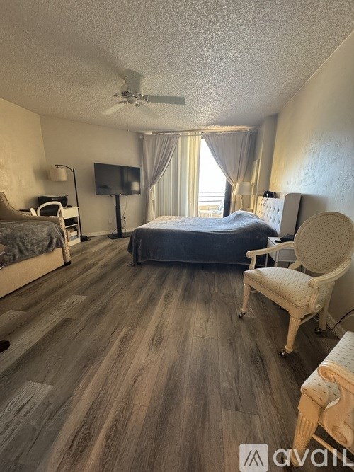 A bedroom with a bed, chair, and television.