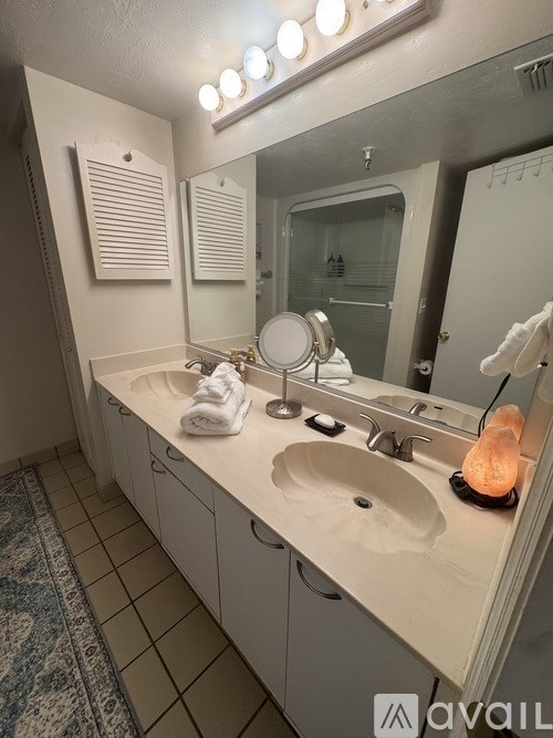 A bathroom with a rug on the floor and a sink with a mirror above it.