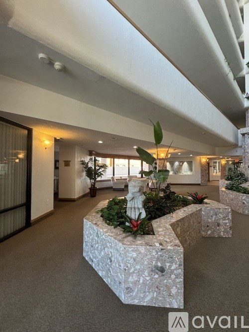 A large indoor space with a stone planter in the foreground.