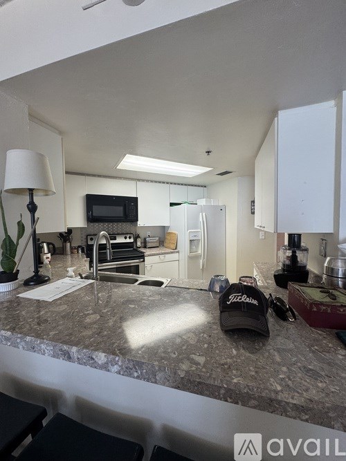 A kitchen with granite countertops and a TV above the stove.