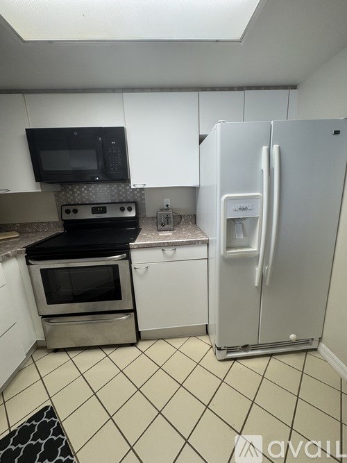 A kitchen with white cabinets and a white fridge.