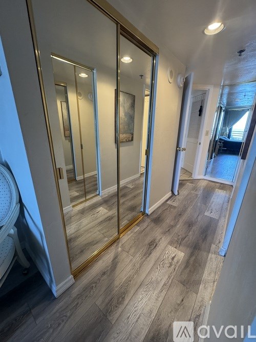 A hallway with a wooden floor and a glass door.
