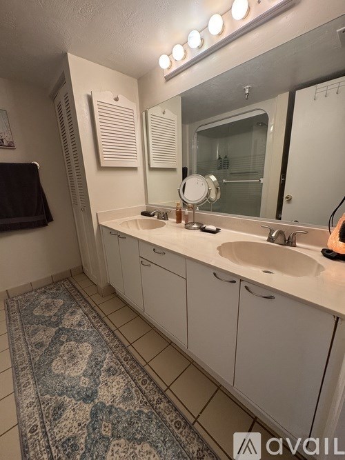 A bathroom with a sink, mirror, and lighting.
