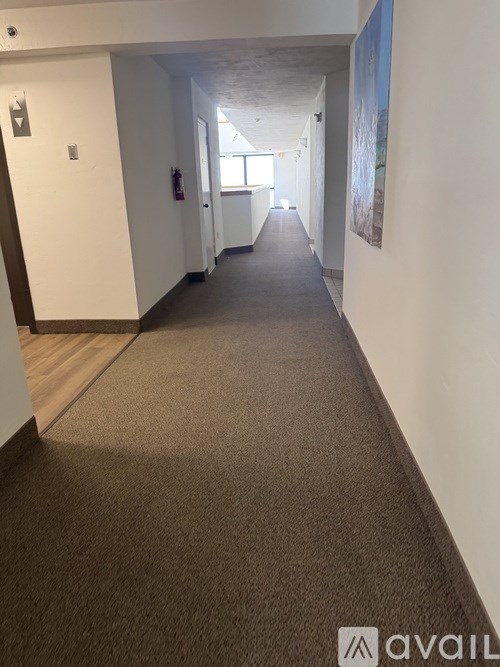 A long hallway with a carpeted floor and white walls.