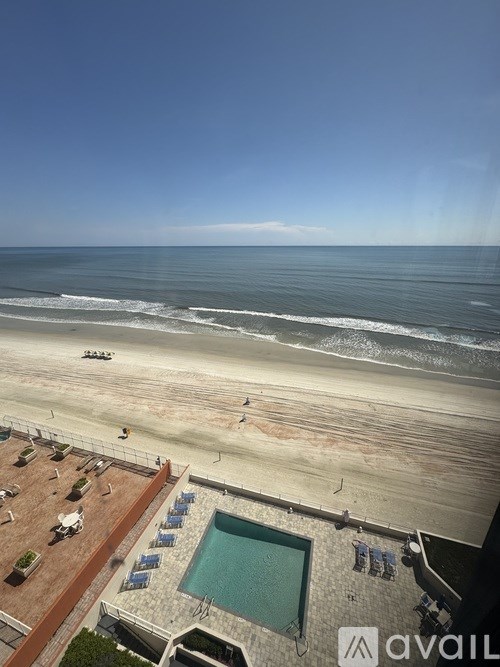 A beachfront property with a pool and beach in the background.