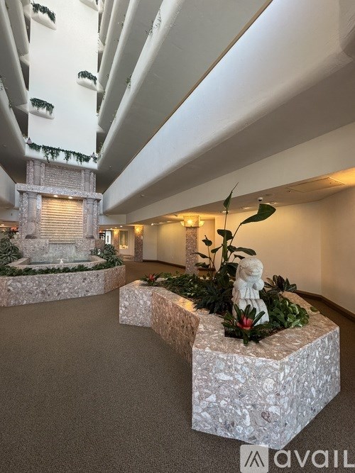 A white marble bench with a plant on it in a hallway.