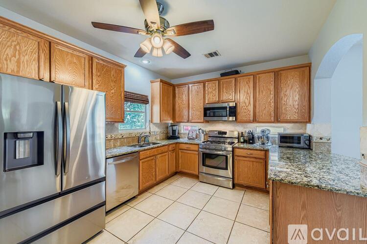 A kitchen with wooden cabinets and a stainless steel refrigerator.