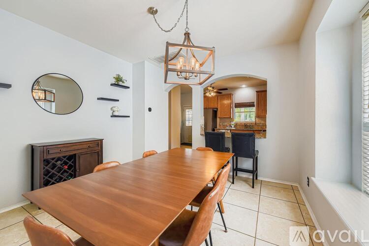 A dining room with a wooden table and chairs.