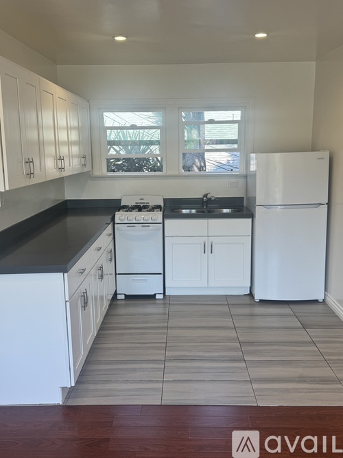 A kitchen with white appliances and cabinets.