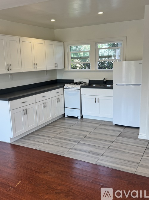 A kitchen with white cabinets and a white fridge.