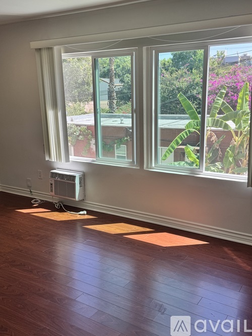 A room with a window and a fan on the floor.