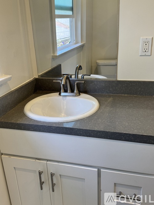 A white sink with a chrome faucet in a modern bathroom.