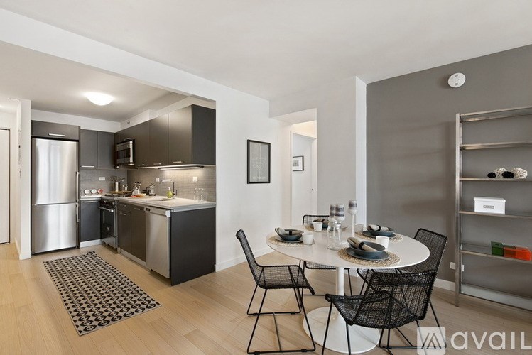 A modern kitchen with a dining table set for two.