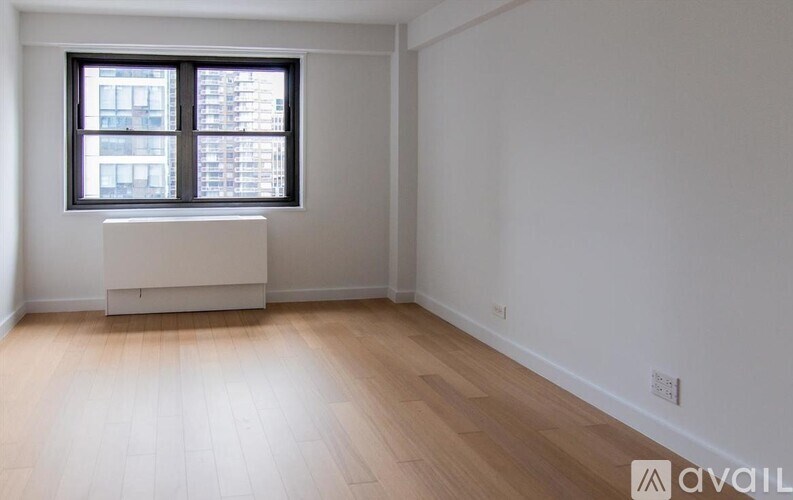 A room with a window and wooden flooring.