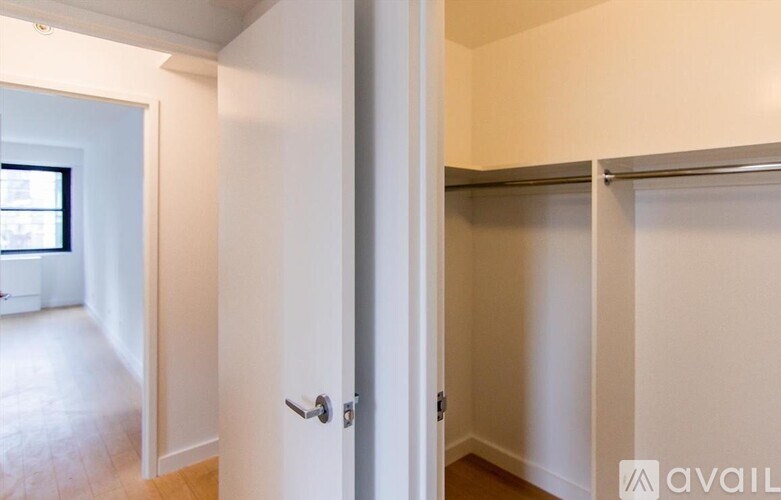 A white door is open to a room with a window.