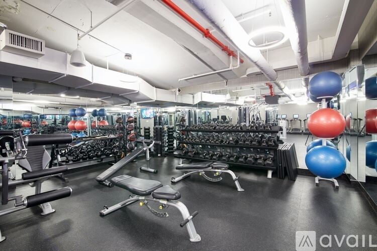 A gym with a variety of equipment including weights and exercise balls.