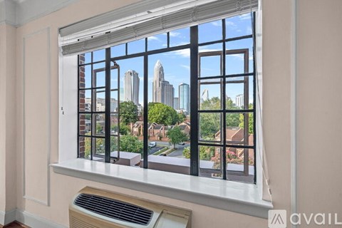 A large white building with a green tree in front of it.