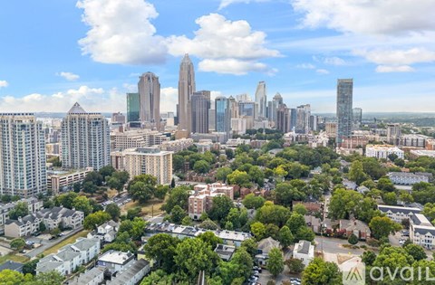A cityscape with a mix of residential and commercial buildings under a clear sky.